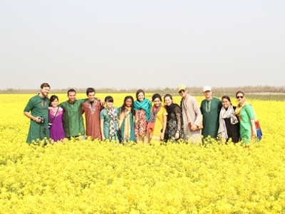 A group stands in a vibrant yellow field of flowers in Asia