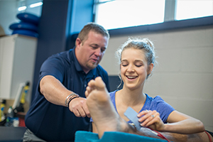 trainer teaching girl how to wrap a foot 