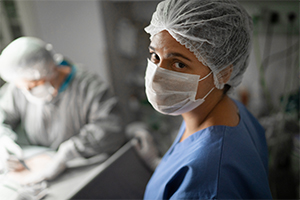 woman in blue scrubs assisting in surgery