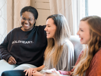 Three girls laughing on couch