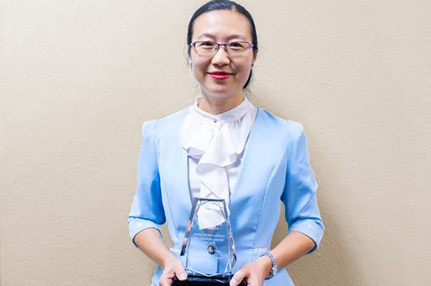 Piper Professor of the Year - Dr. Christina Chen holding an award