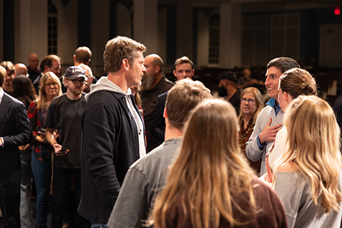 Dallas Jenkins standing and talking with people