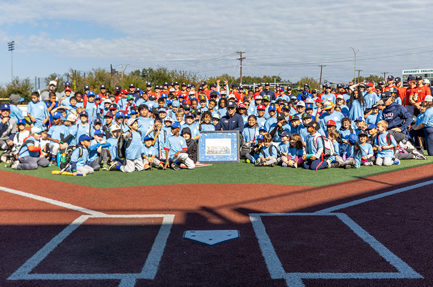 group picture of Mercy Street and DBU baseball team on a baseball field