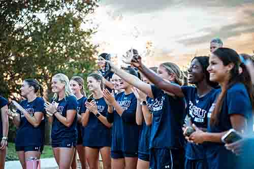 DBU Soccer team cheering their teammate on as she got baptized