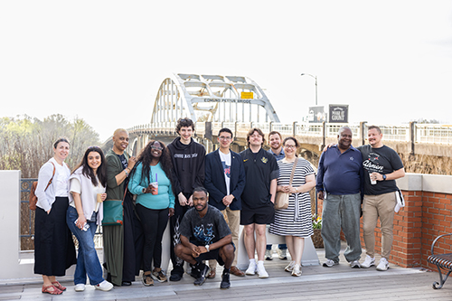 group of students standing by a bridge