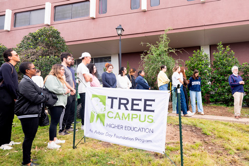 Students around Tree Campus USA banner at the tree planting