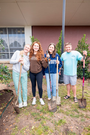 Students with shovels at tree planting ceremony on campus