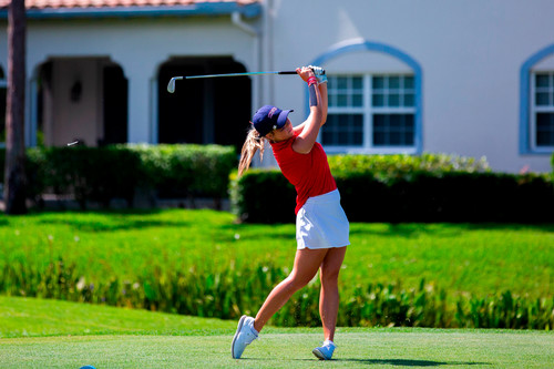DBU golfer mid-swing on course in red and white team uniform