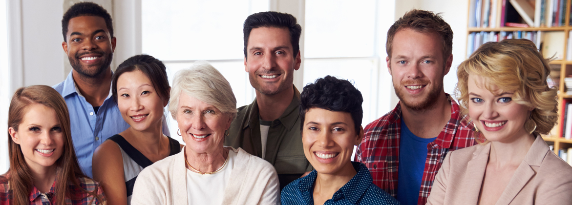 group of 8 people of various ages & backgrounds - inside with a bookshelf in the background