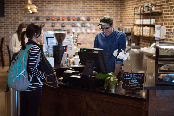 a barista assists a customer