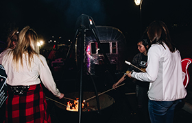 picture of a group of girls gathered around a bonfire