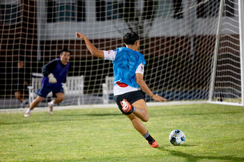 Student kicking a soccer ball