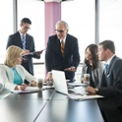 working professionals gathered around a table working on a group project together