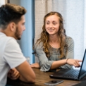 dallas college students sitting at a table looking at a laptop