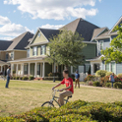 college student riding bike near townhomes