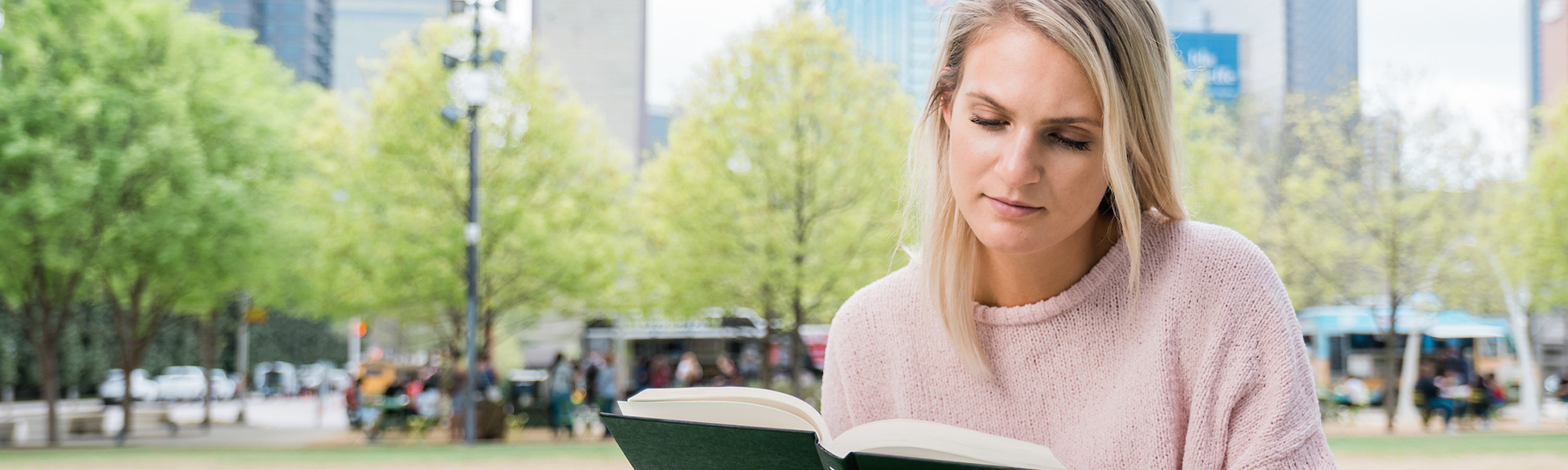 a girl reads in downtown dallas
