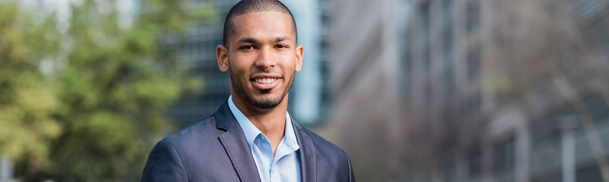 a young man stands in front of a building in Dallas