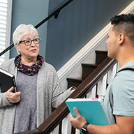 picture of male student talking with a professor by stairs