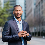 picture of a man smiling in a suit standing in a street in Dallas 