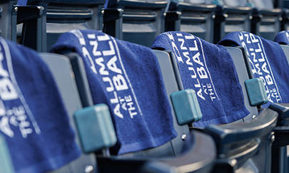 dallas baseball stadium bleachers with DBU alumni towels draped over the back of the stadium seats