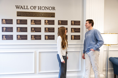 students talking near teh wall of honor in the Center for Baptist History