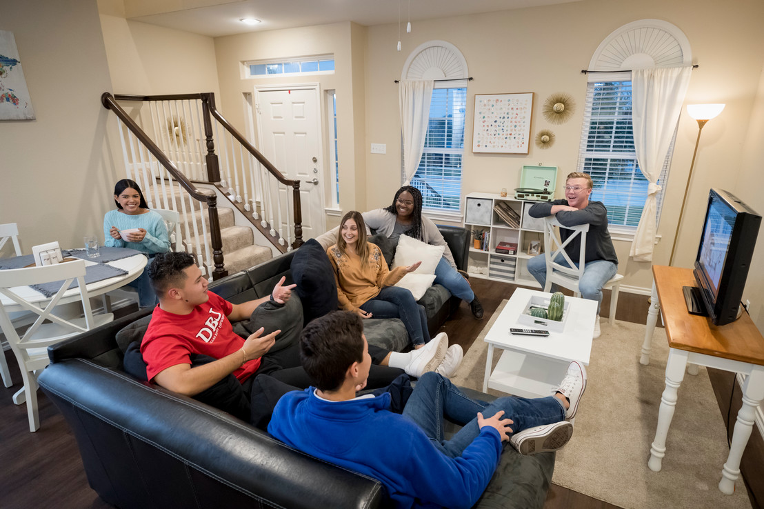 college students hanging out with friends in a living room watching TV in Dallas, Texas