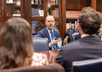 Knox Thames discussing at table