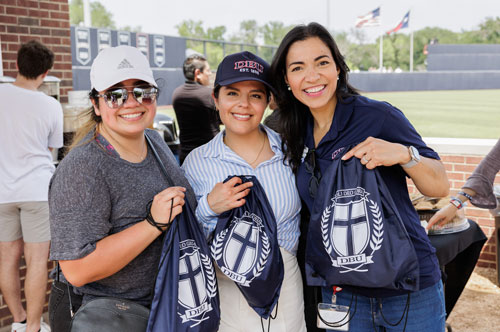 two girls standing at the ballpark holding DBU drawstring bags