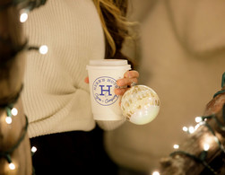woman holding disposable coffee cup and Christmas ornament