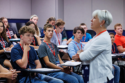 teacher a classroom of high school students listening to a female music instructor