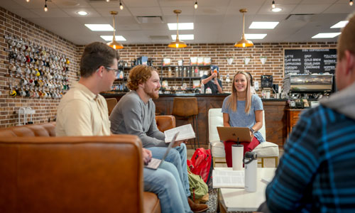 college students sitting and talking on the couches in the DBU Coffeehouse