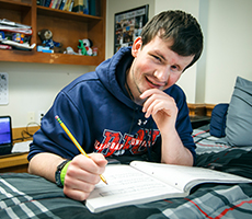 Residence Life guy college student studying in Stone House in the williams dorms