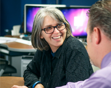 student in computer lab talking to professor