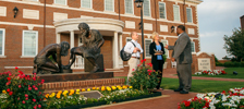  Three individuals conversing by the statue in front of Blackaby Hall.