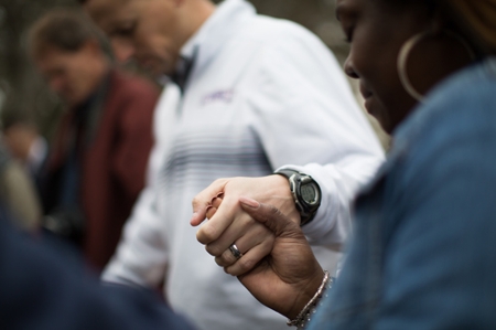 Everyone gathered joining hands and bowing heads in prayer