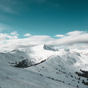 1. A photos of snowy mountains and low, hanging white clouds touching them, and the sky is turquoise blue