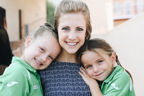 Three girls, two are children wearing green shirts