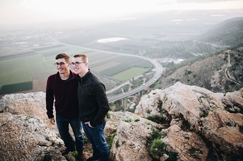 Two guys posing outside on top of a mountain / hill / boulders during a travel study trip