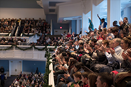 Commencement crowd looks onward as they anticipate their graduate receiving their diploma.