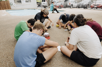 picture of Kathleen praying with a group of kids in a circle