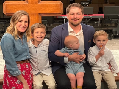 picture of Jordan Mckinney, his wife, and three kids at Church