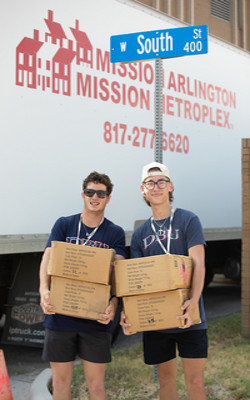picture of two DBU students holding boxes serving at Mission Arlington