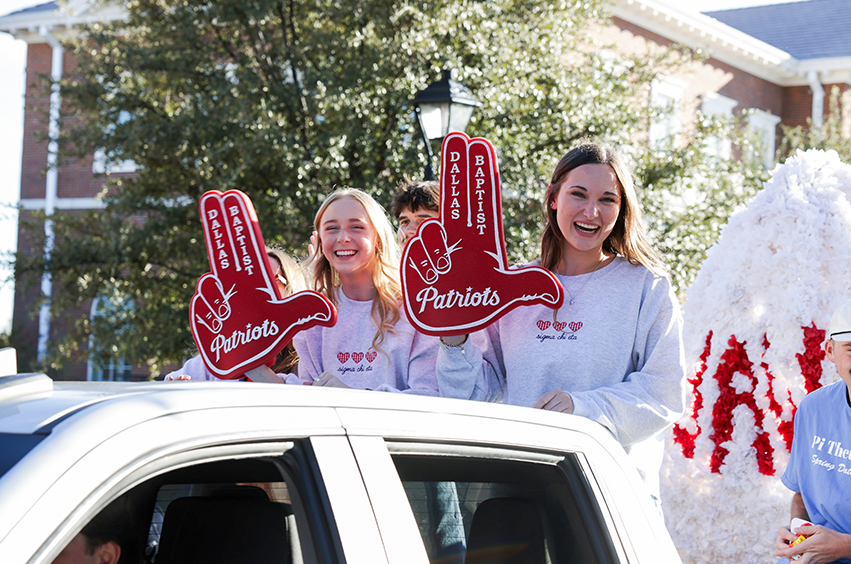 college students smiling on a Homecoming float in Dallas