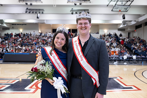 Homecoming Queen and King standing on basketball court
