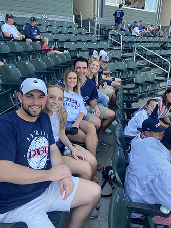Mitch Cantwell sitting in the stadium at a DBU Patriots Baseball game with friends