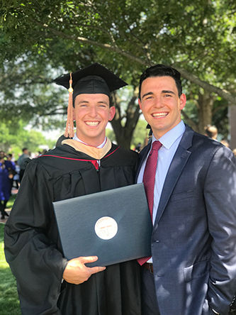 Mitch Cantwell standing outside after master's graduation with brother