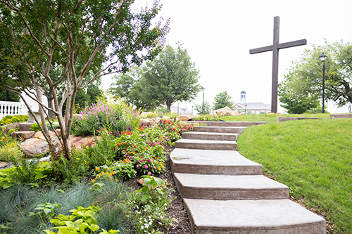 outside stairs leading up to a cross with beautiful landscaping in Dallas, Texas