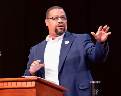 Pastor Chip Luter preaching behind a wooden church pulpit