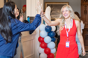 new college student walking with excitement with people cheering for her