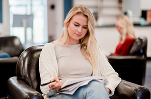 a college student is sitting in a chair at a local coffee shop, budgeting for college expenses